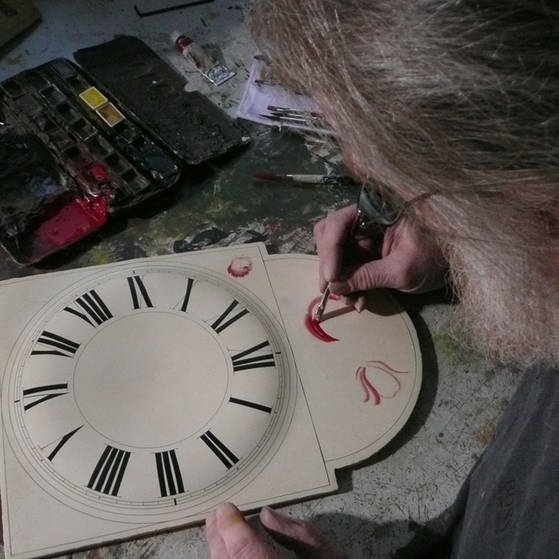 Schildermaler bemalt Uhrenschild