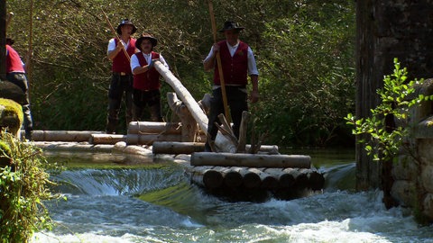 Mehrere Flößer auf bewegtem Fluss