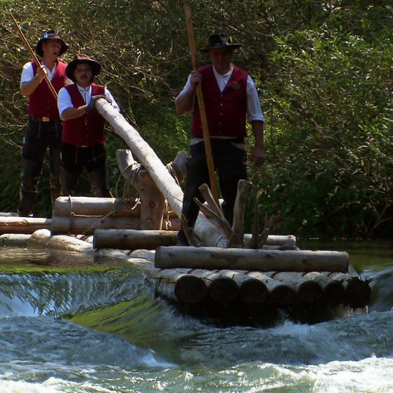 Mehrere Flößer auf bewegtem Fluss
