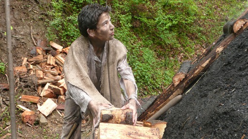 Junge arbeitet am Meiler