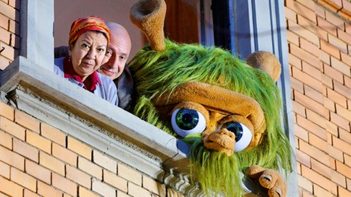 Mumbro, und zwei weitere Personen schauen aus dem Fenster