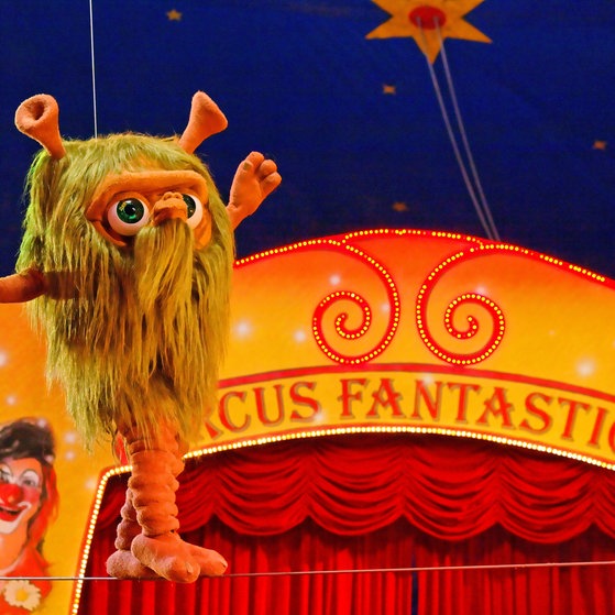 Figur Mumbro balanciert auf einem  Seil.