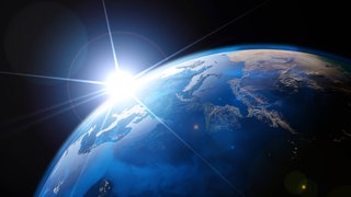 Auf der sonnenbeschienenen Seite der Erde ist Tag, auf der Rückseite Nacht.