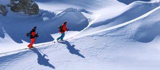 Zwei Skifahrer werfen lange Schatten