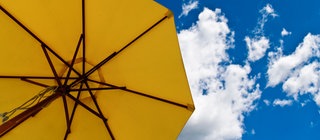 Sonnenschirm im blauen Himmel: Das Ozonloch lässt die gefährliche UV-Strahlung der Sonne auf die Erde.