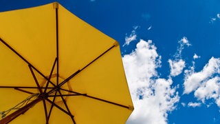 Sonnenschirm im blauen Himmel: Das Ozonloch lässt die gefährliche UV-Strahlung der Sonne auf die Erde.