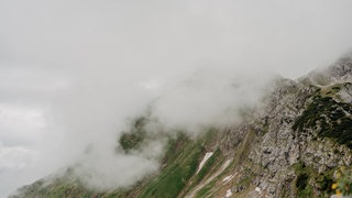 Nebel verdeckt den Gipfel eines Gebirges. Er entsteht vor allem im Herbst, wenn die Luft immer weiter abkühlt und Wolken direkt über der Erdoberfläche entstehen.