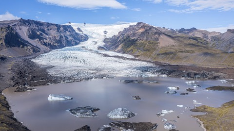 Ansicht einer Gletscherzunge mit Gletschersee im Vordergrund. Riesige Eismassen formten über viele Jahre hinweg die Landschaft.