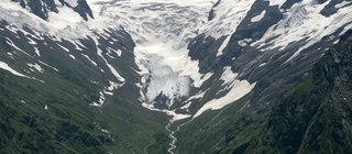 Panoramasicht auf ein Gletschertal. In Form von Gletschereis formt Wasser kerbförmige Flusstäler zu runden Trogtälern.