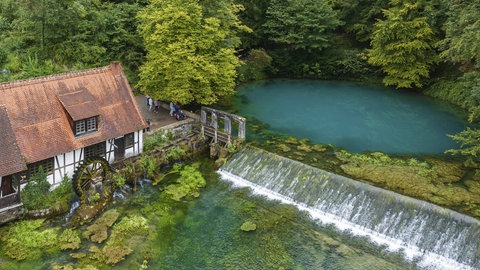 Auf der schwäbischen Alb versickert Regenwasser im Boden. An einer Quelle namens Blautopf tritt das Grundwasser wieder aus.