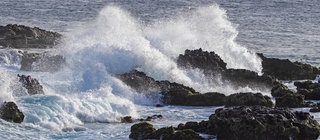 Meer und Ozeane - Brandung am Felsstrand: Wasser spritzt gegen die Steine am Ufer. 