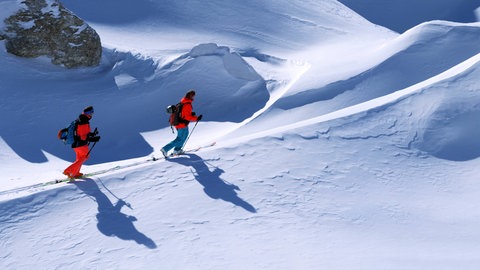 Zwei Skifahrer werfen lange Schatten
