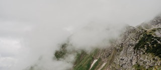 Nebel verdeckt den Gipfel eines Gebirges. Er entsteht vor allem im Herbst, wenn die Luft immer weiter abkühlt und Wolken direkt über der Erdoberfläche entstehen.