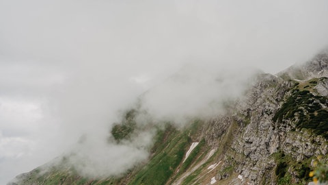 Nebel verdeckt den Gipfel eines Gebirges. Er entsteht vor allem im Herbst, wenn die Luft immer weiter abkühlt und Wolken direkt über der Erdoberfläche entstehen.