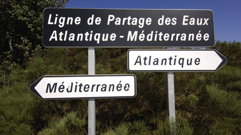 Schilder markieren den französischen Teil der Wasserscheide zwischen Mittelmeer und Atlantik.
