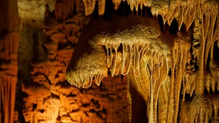 Tropfsteinhöhlen mit riesigen Säulen in Karst-Landschaften.