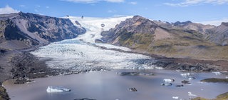 Ansicht einer Gletscherzunge mit Gletschersee im Vordergrund. Riesige Eismassen formten über viele Jahre hinweg die Landschaft. 