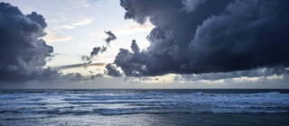 Dunkle Wolken türmen sich über dem Meer. Verdunstung und Niederschlag sind wichtig für den Wasserkreislauf.