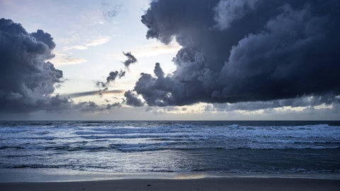 Dunkle Wolken türmen sich über dem Meer. Verdunstung und Niederschlag sind wichtig für den Wasserkreislauf.