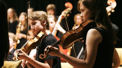 Ein Junge und ein Mädchen spielen Geige