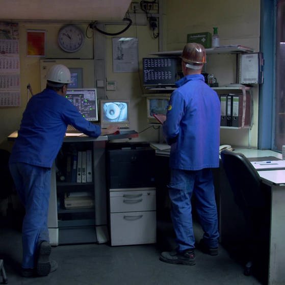 Zwei Männer im Blaumann vor Monitor. (Foto: SWR – Screenshot aus der Sendung)