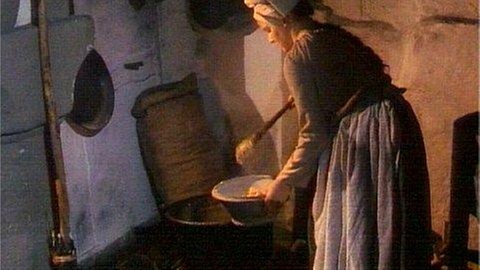 Magd bei der Essenszubereitung