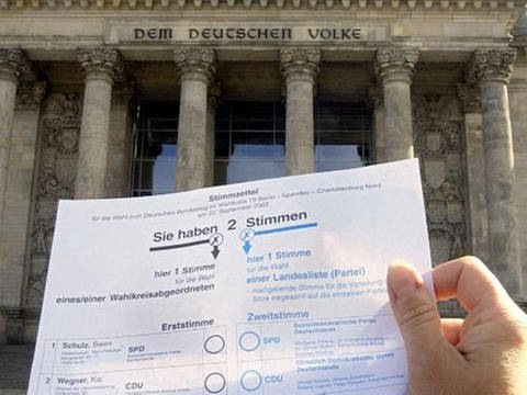 Wahlzettel zur einer Buntestagswahl im Vordergrund, im Hintergrund Portal des Reichstagsgebäudes (Foto: dpa)