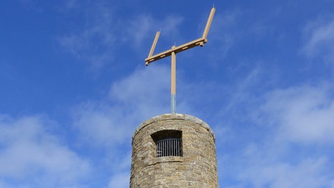 Ein runder Steinturm mit einem optischen Telegraph auf der Spitze. Damit wurde früher über weite Strecken kommuniziert.