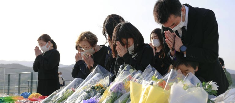 Menschen beten und trauern um die Opfer des Tsunami in Japan 2011. (Foto: IMAGO, IMAGO / Kyodo News)