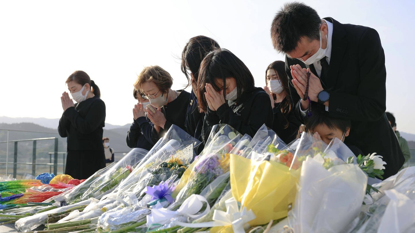 Menschen beten und trauern um die Opfer des Tsunami in Japan 2011. (Foto: IMAGO, IMAGO / Kyodo News)