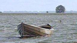 Ein kleines Holzboot schwimmt auf dem Wasser.