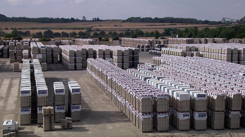 Gestapelte Bimssteine auf Firmengelände.