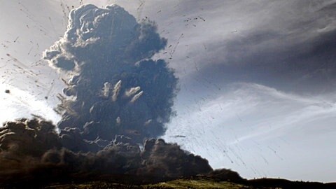 Es ist eine Simulation zu sehen, wie bei einem Vulkanausbruch eine graue Aschewolke aufsteigt.