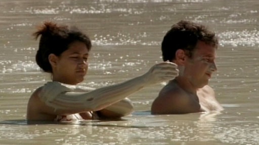 Zwei Badende in schlammigem See.