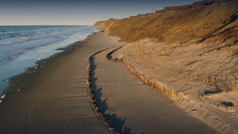 Bild eines Leuchtturms am Meer. Daneben der Schriftzug 