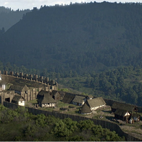 Kleine Siedlung aus Holz-Lehm-Häusern auf einem Berg.