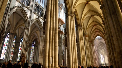 Menschen feiern die Ostermesse im Kölner Dom