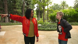 Eine Frau zeigt einem Jungen den Weg.