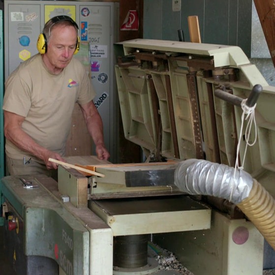 Martin Sammet mit Ohrschützern an einer Säge.