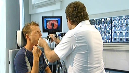 Arzt schaut Sänger mithilfe einer kleinen Optik in den Rachen (Foto: SWR - Screenshot aus der Sendung)