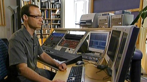 Filmkomponist Christian Kardeis sitzt vor vielen Monitoren (Foto: SWR - Screenshot aus der Sendung)