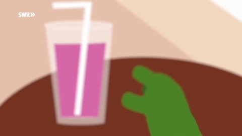 Ein verschwommenes Bild von einem Glas aus der Sicht der Schildkröte, die danach greift