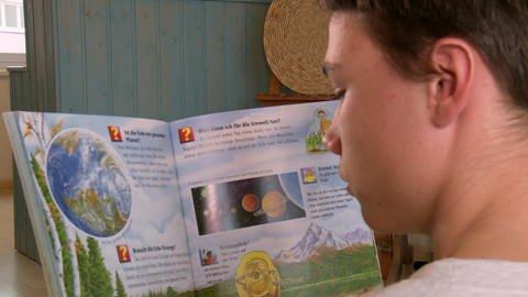 Junge liest Bilderbuch (Foto: SWR - Screenshot aus der Sendung)