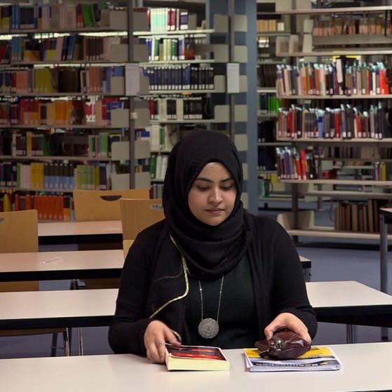 Junge Frau mit Kopfschleier in Bibliothek. (Foto: SWR – Screenshot aus der Sendung)