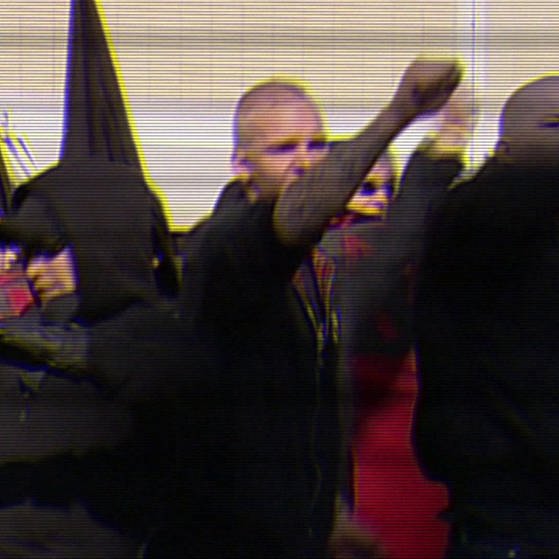 Demonstranten bei einer Versammlung von Neonazis mit Fahnen. (Foto: SWR – Screenshot aus der Sendung)