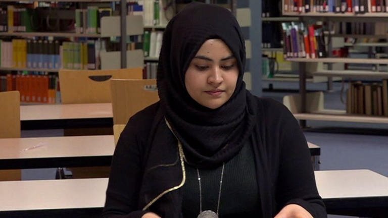 eine Frau mit Kopftuch sitzt in einer Bibliothek (Foto: SWR – Screenshot aus der Sendung)