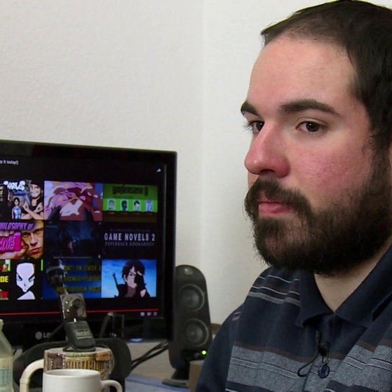 Gabriel neben einem Computerbildschirm.