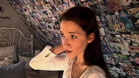 Mädchen vor einer Bilderwand.