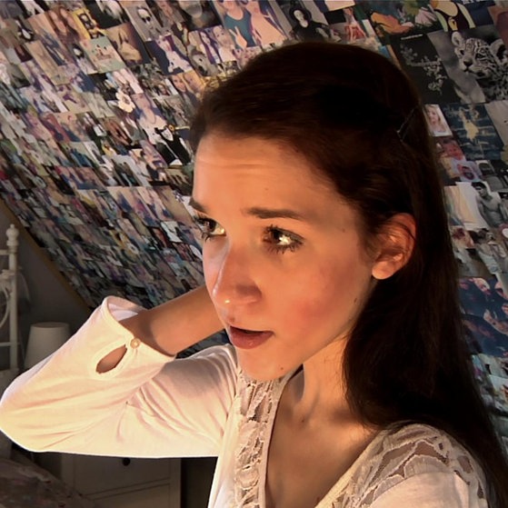 Mädchen vor einer Bilderwand.