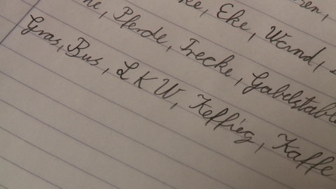 Mann sitzt an einem Tisch mit Papieren vor sich